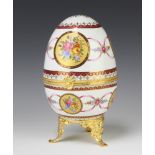 A 20th Century painted porcelain, gilt metal mounted egg decorated with spring flowers 23cm