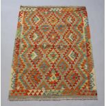 A yellow, green and lime ground Chobi Kilim rug with all over diamond design 150cm x 105cm