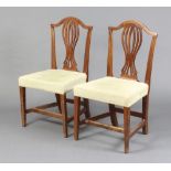 A pair of Georgian oak Hepplewhite style camel back dining chairs with pierced vase shaped slat