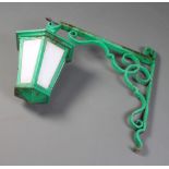 A hexagonal green painted iron hanging lantern 30cm x 34cm with wrought iron bracket 64cm h