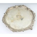 A Victorian silver salver with chased decoration and fancy rim on claw and ball feet, London 1872,