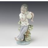 A Lladro figure of a boy playing a drum , resting against a tree bough "Lladro Black Legacy Bongo