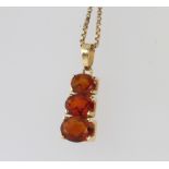 A 9ct yellow gold garnet 3 stone pendant on a ditto chain together with 2 9ct yellow gold rings,
