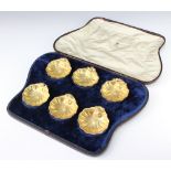 A cased set of silver gilt Faberge shell shaped table salts, the handles with entwined mice and a