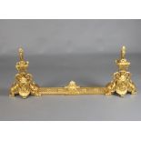 A French gilt metal Rococo style fire curb with 2 pierced gilt metal end irons in the form of lidded