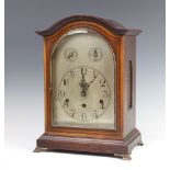 A German bracket clock, striking on a gong, with arched silvered dial contained in an inlaid
