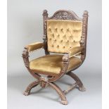 A Victorian, Italian style carved oak open arm chair raised on X framed supports, the seat and