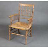 A William Morris style elm stick and rail back carver chair with woven rush seat There is some