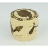 A Meiji period Japanese turned ivory cylindrical box with lacquered decoration the lid with a mask