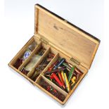 A wooden box containing various lures and hooks