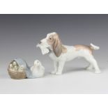 A Lladro figure of a basset hound holding a newspaper in his mouth 17cm and a ditto of a family of
