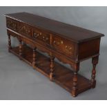 A 17t/18th Century style oak dresser base fitted 4 drawers with cupboard beneath, raised on turned