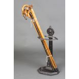 A Victorian style cast iron umbrella stand with eagle decoration containing a collection of