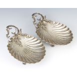 A pair of 19th Century French silver scallop shaped dishes with scrolling floral handles, 24cm 608