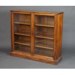 A Victorian light oak display cabinet/bookcase fitted shelves enclosed by glazed panelled doors,