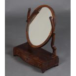 A 19th Century oval plate dressing table mirror contained in a mahogany swing frame, the base of