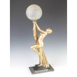 An Art Deco style plaster table lamp in the form of a standing naked lady holding a globe, raised on