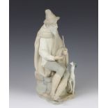 A Lladro matt figure of a seated gentleman with hound at his feet 27cm