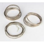 Twenty four silver bangles, 102 grams