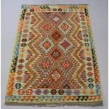 An orange, green and lime ground Chobi Kilim rug 195cm x 127cm