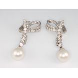 A fine pair of platinum, diamond and detachable baroque pearl bow ear drops, comprising 34 brilliant