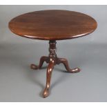 A circular Georgian mahogany snap top tea table, raised on a turned column and tripod base 76cm h