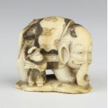 A Meiji period Japanese carved ivory and shibayama Netsuke in the form of a man standing beside an