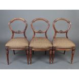 A set of 3 Victorian carved walnut balloon back dining chairs with carved and pierced mid rails