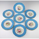 Eleven Continental porcelain dessert plates with blue and gilt borders enclosing spring flowers 21cm