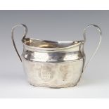 A Georgian silver 2 handled sugar bowl with chased armorial and scroll decoration 18cm, 229 gramsThe