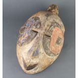 A carved wooden and painted tribal mask 40cm x 25cm