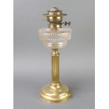 A Victorian circular faceted glass oil lamp reservoir raised on a reeded brass column 42cm h x