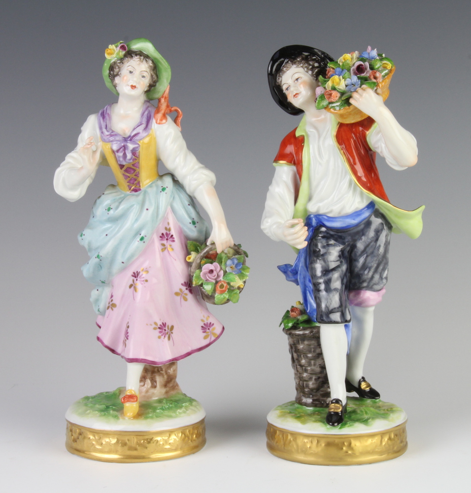 A pair of German porcelain figures of flower sellers raised on circular bases 21cm Both have minor