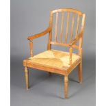 A 19th Century French fruitwood stick and rail back open arm carver chair with woven rush seat,
