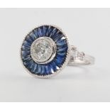 A platinum diamond and sapphire target ring, the centre stone approx. 1.01ct surrounded by calibre