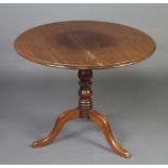 A 19th Century circular mahogany snap top tea table, raised on baluster turned column and tripod