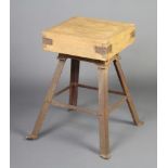 A square pine butcher's block raised on an associated iron stand with outswept supports 74cm h x