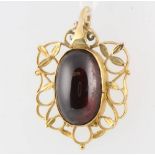 A yellow gold cabochon cut garnet pendant 32mm