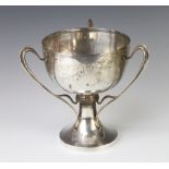An Arts and Crafts style 3 handled trophy cup, Sheffield 1910, 867 grams, 12cm There are minor dents