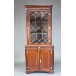 A 19th Century inlaid mahogany double corner cabinet with moulded cornice, fitted shelves enclosed