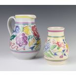 A Poole Pottery jug decorated with stylised birds and flowers 20cm, a baluster vase 15cm and a