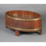 An Edwardian oval coopered oak planter 36cm h x 76cm w x 48cm d There is some damage to the interior