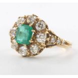 An 18ct yellow gold emerald and diamond cluster ring, the centre stone 1.20ct surrounded by