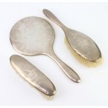 A silver backed hand mirror Chester 1913, a clothes brush and hair brush, different marks