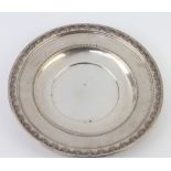 A circular sterling silver dish with repousse scroll decoration 175 grams, 24cm