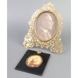 A pierced gilt metal easel photograph frame 22cm x 19cm together with a black and white portrait