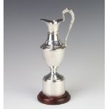A silver golf trophy in the form of an urn with presentation inscription, raised on a wooden socle