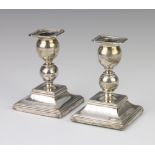 A pair of Russian silver dwarf candlesticks, stamped 84 and with inscription, 11cm Both are slightly