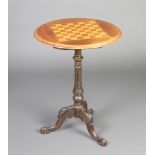 A Victorian circular games table, the top inlaid a chessboard, raised on a turned and fluted