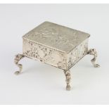 A Dutch repousse silver rectangular box decorated with birds and motifs, raised on scroll feet 55mm